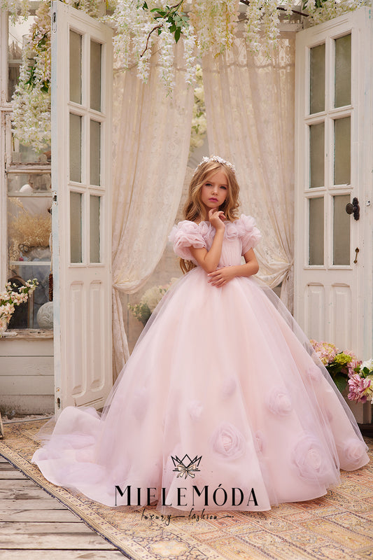 pretty flower girl wearing pink tulle dress with 3d flowers standing in front of open doors with hanging ivory wisteria