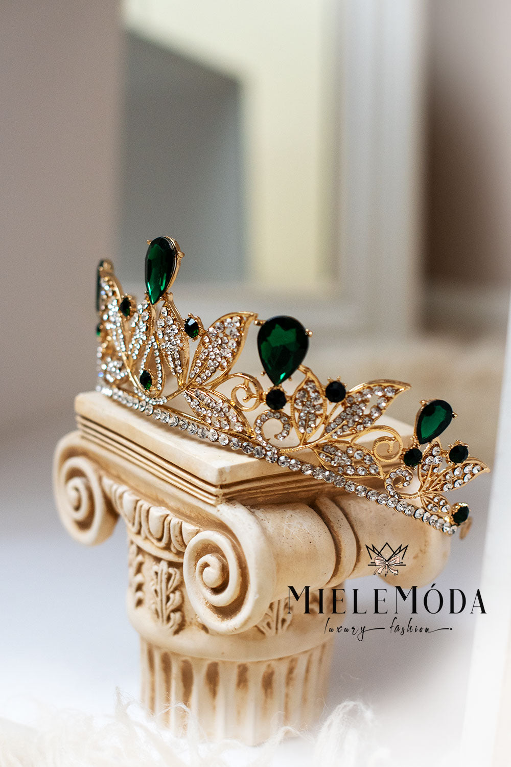 emerald and gold rhinestone crown princess tiara standing on a greek column