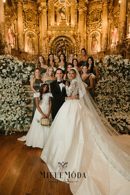 Jasmine Tooks wearing Zuhair Murad wedding gown standing next to her flower girl Chloe wearing Miele Moda gown with her bridal party and husband Juan David Borrero in front of the alter